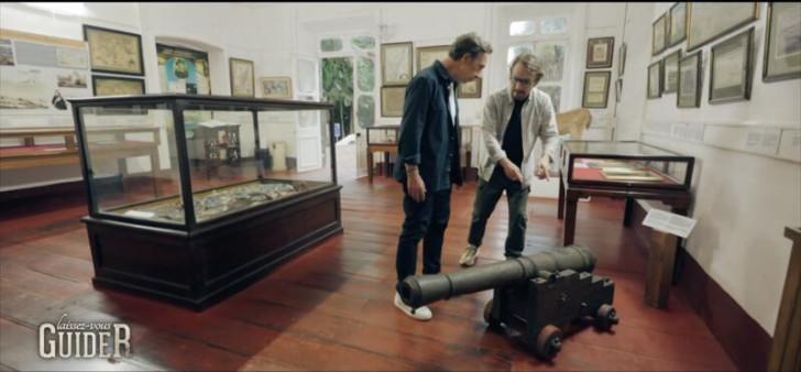 Stéphane Bern et Lorànt Deutsch regardant un canon présenté dans un musée (sur l'Île Maurice)